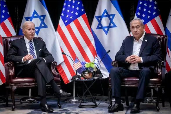 جو بایدن در کنار بنیامین نتانیاهو، پشت ردیفی از پرچم های اسرائیل و آمریکا نشسته است.